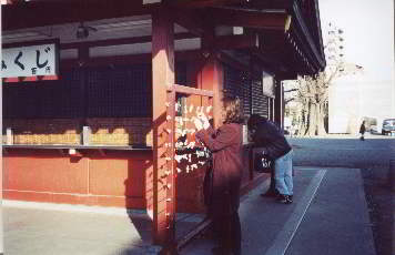 Young Japanese woman selects fortune slip